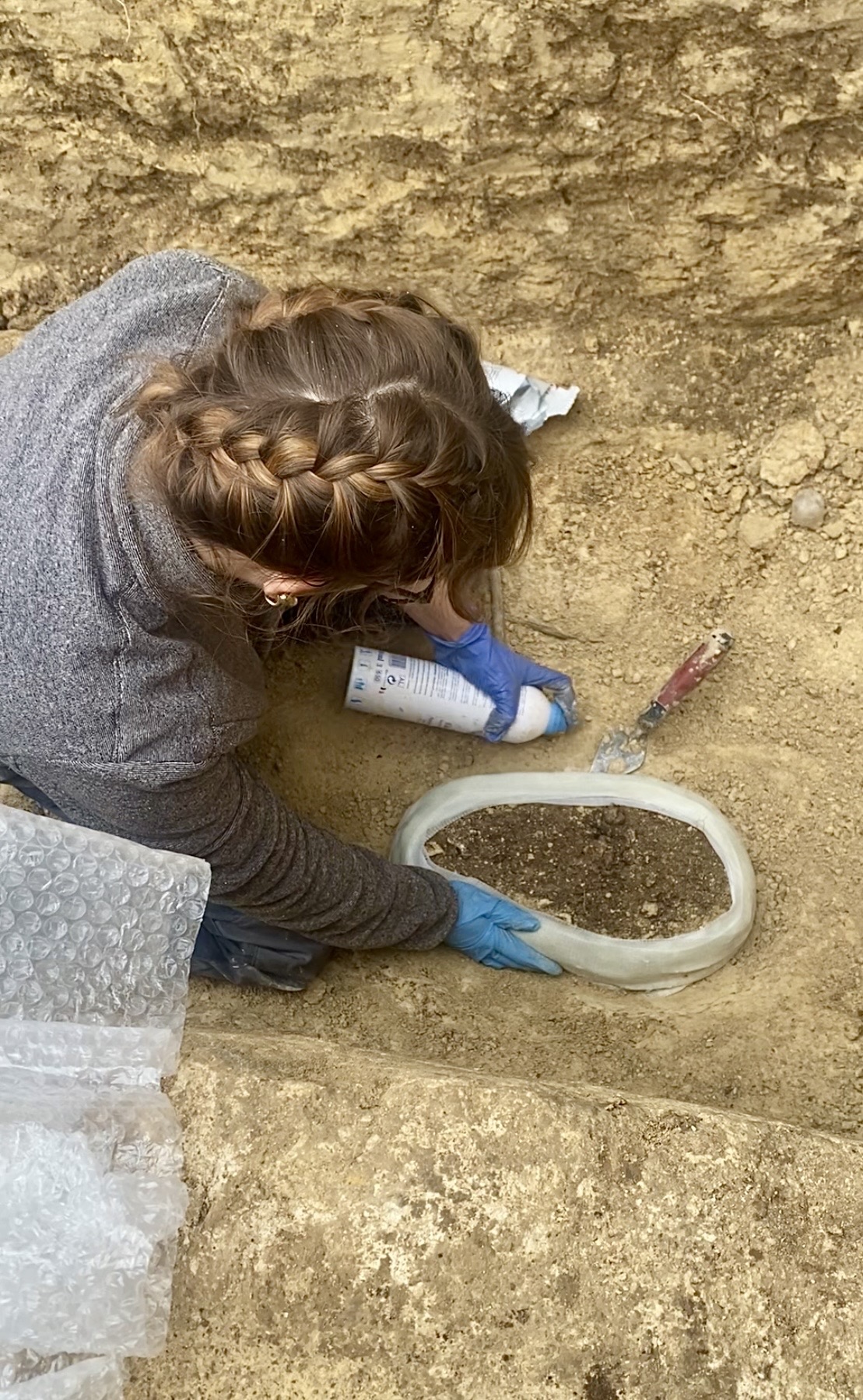 Prélèvement d'un vase archéologique en motte, en cours de fouille